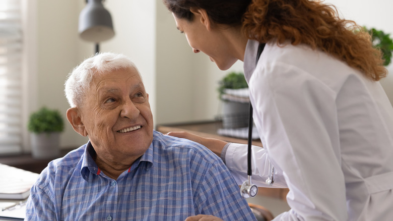 Doctor and patient holding hands and smiling