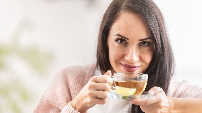 Smiling woman holding green tea
