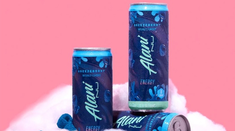 3 cans of Alani Nu energy drink on cloud