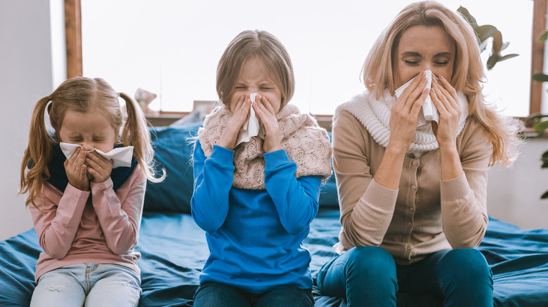 mom and daughters blowing their nose