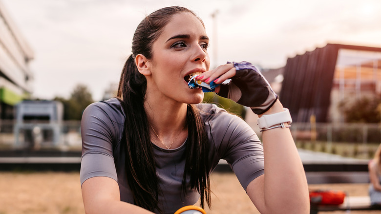 woman eating a protein bar post-workout