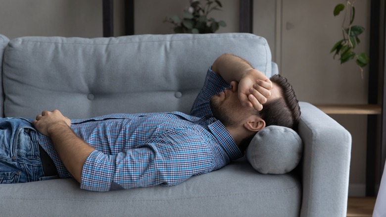 Depressed man napping on couch