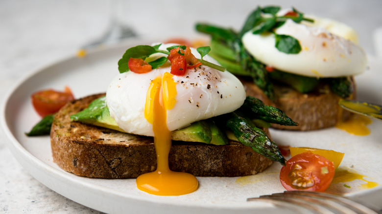 dripping poached eggs and avocado on toast