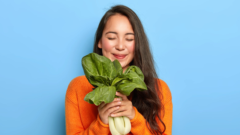 woman holding handful of leafy greens 