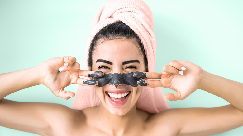 smiling woman with charcoal mask