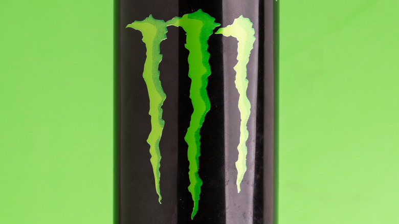 Can of Monster Energy against green background