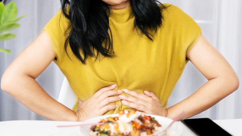 Woman having abdominal pain while eating