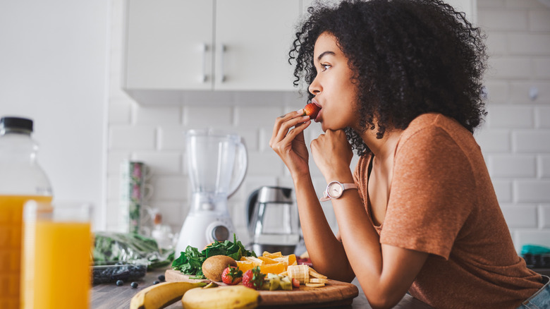 woman eating a bowl of fruit