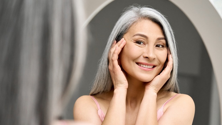 asian woman looking at her reflection