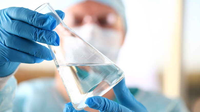 man in a lab with a beaker testing natural flavors