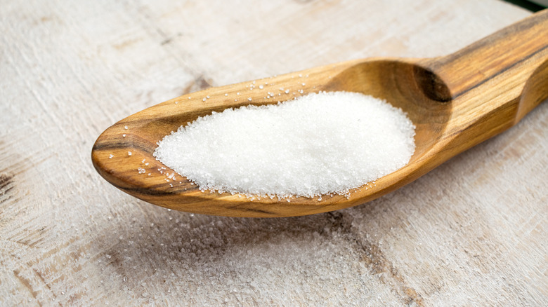 close up photo of sucralose sugar on a wooden spoon