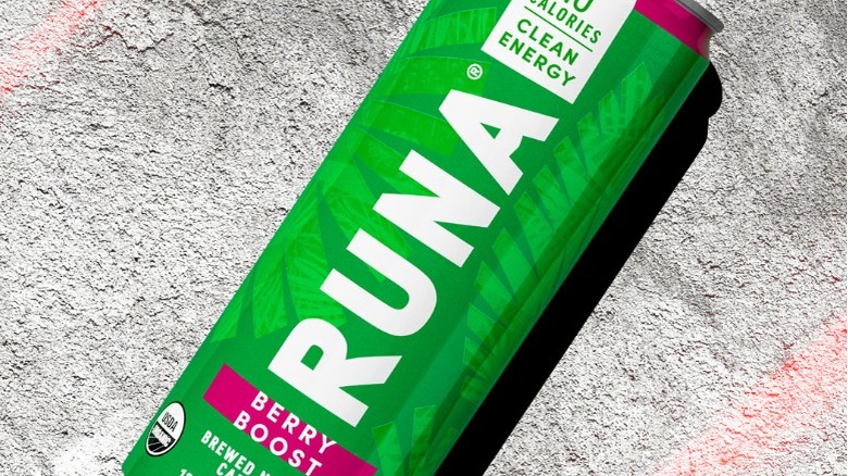 Green can of Berry Boost Runa energy drink on concrete background