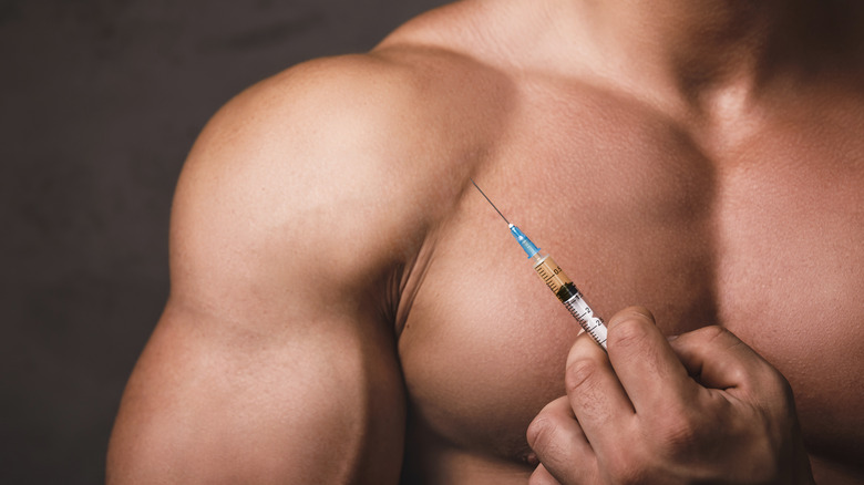 muscular man holding a syringe