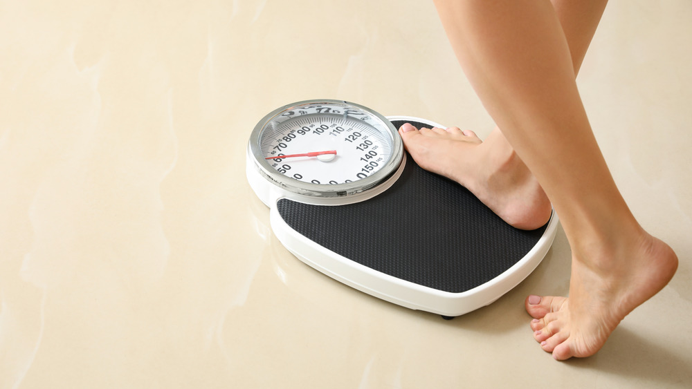 woman stepping on a scale