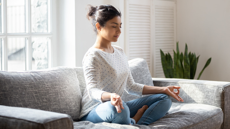 Indian woman sitting on couch meditating