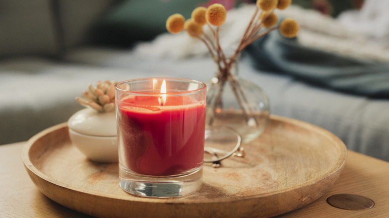 small jar candle on a wood plate