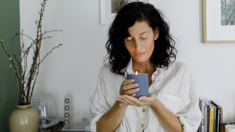 woman savoring the smell of a scented candle