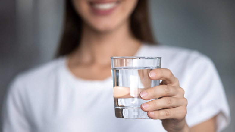 Happy woman holding a glass of water