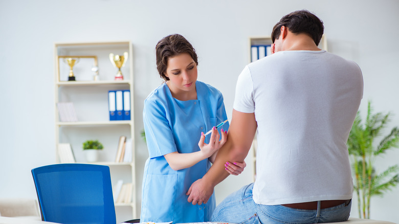 doctor administering a booster shot in office 