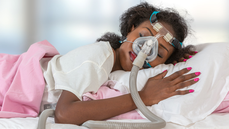 Sleeping woman wearing sleep apnea machine