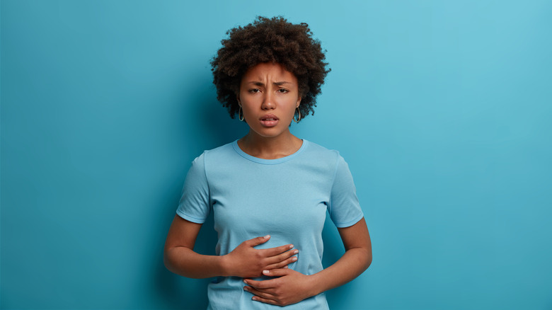 Distressed woman holding her tummy   