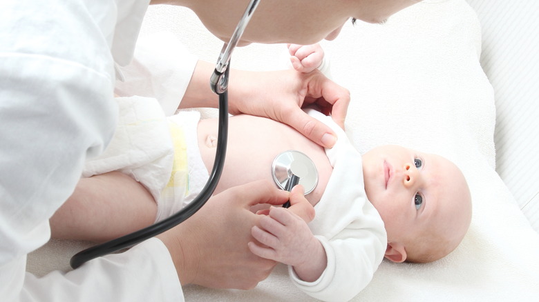 female doctor listening to the heart of baby with stethoscope