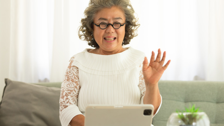 woman waving to computer screen