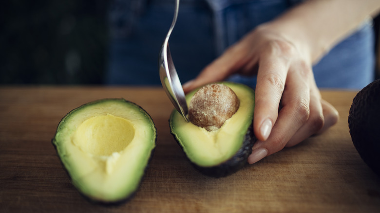 Spooning pit out of avocado