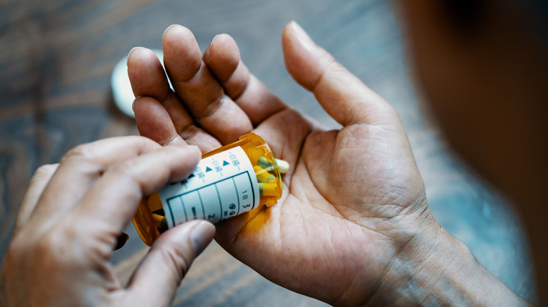 man's hand holding medication