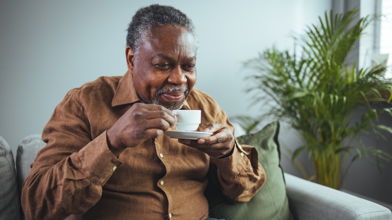 Smiling older man holding tea mug