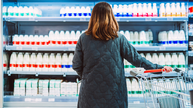 Woman grocery shopping for milk