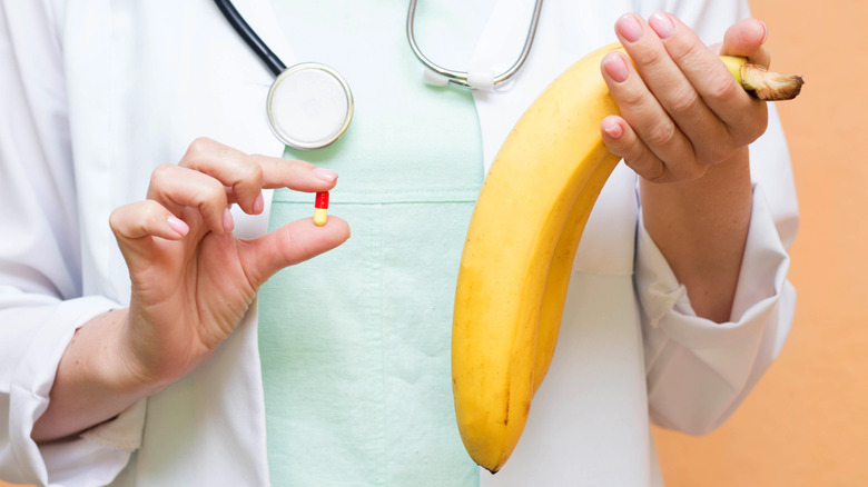 Doctor holding a pill and a banana