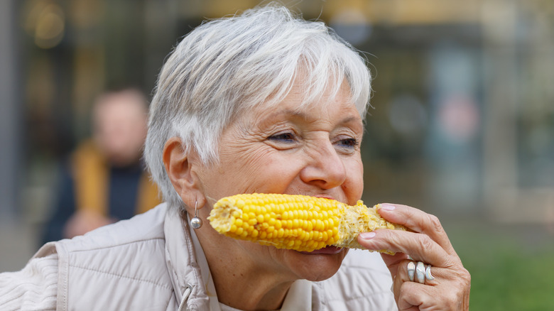 Older woman biting corn on the cob