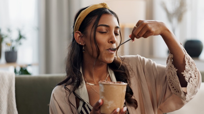 woman eating ice cream out of the container