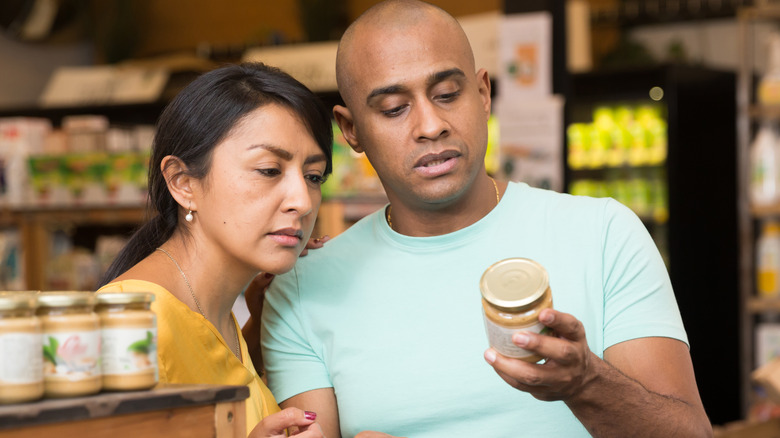 couple looking at the food label on a jar