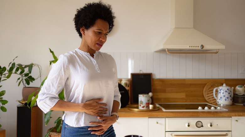 Woman holding stomach in pain