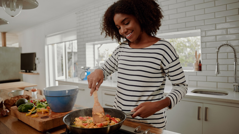 woman cooking a high-fiber stir fry with vegetables