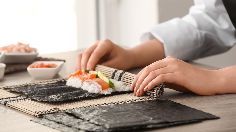 woman's hands rolling sushi