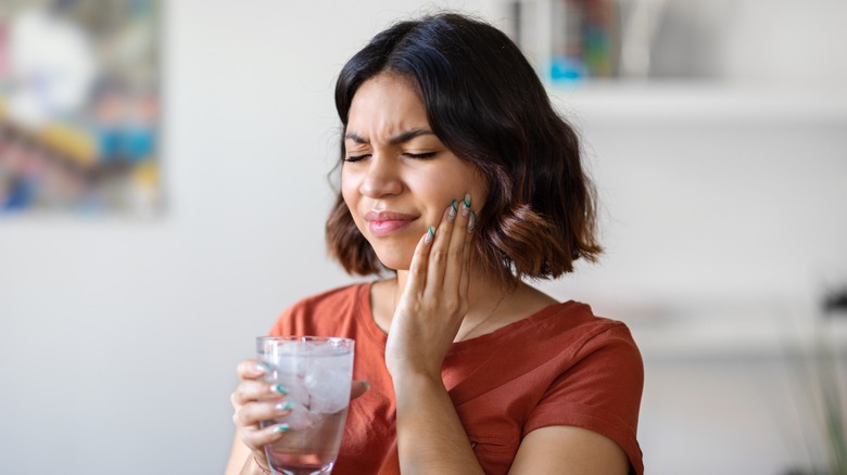 Wincing woman experiencing mouth pain