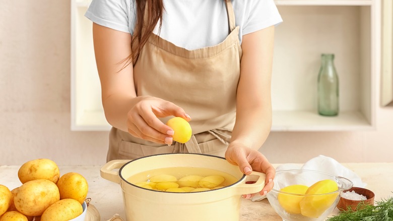 Woman boiling potatoes