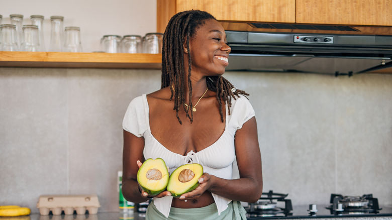 Smiling woman holding avocado