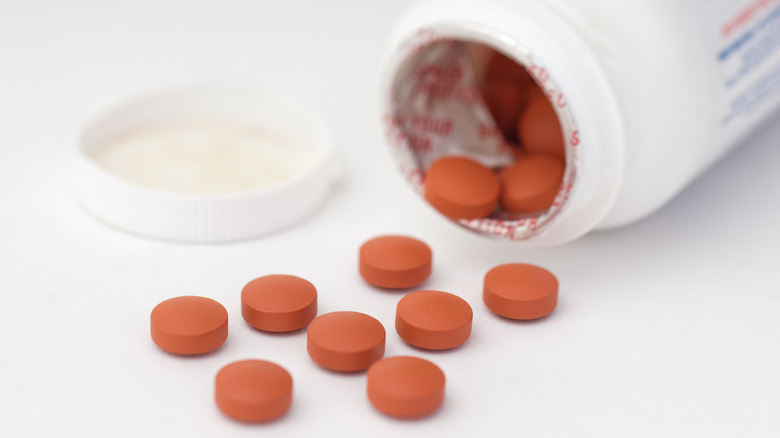 bottle of ibuprofen tablets spilled on table