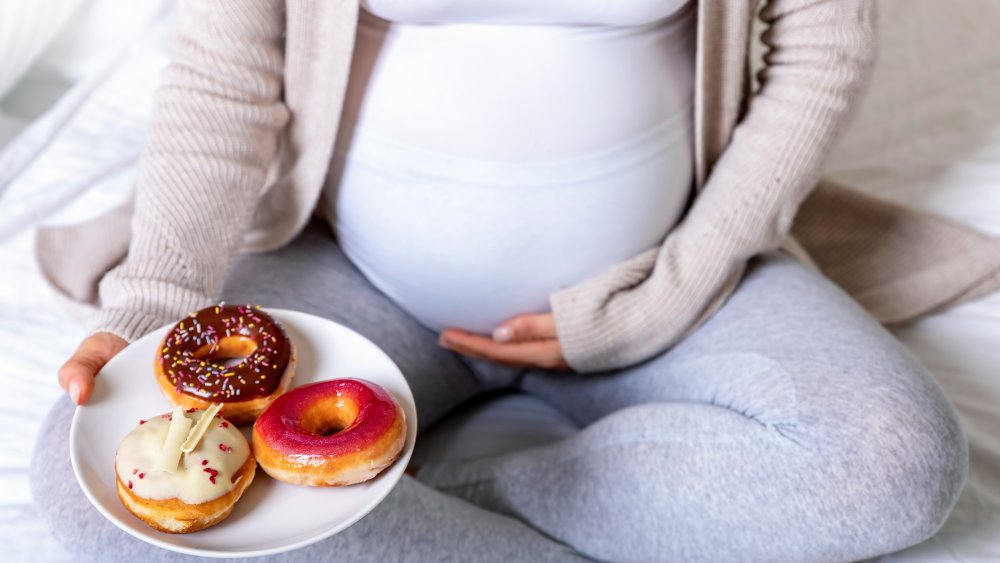 pregnant woman eating donuts