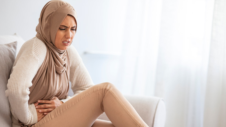 Wincing woman with stomach ache