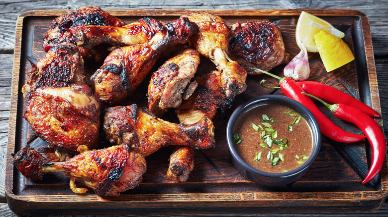 BBQ chicken thighs on a wooden tray