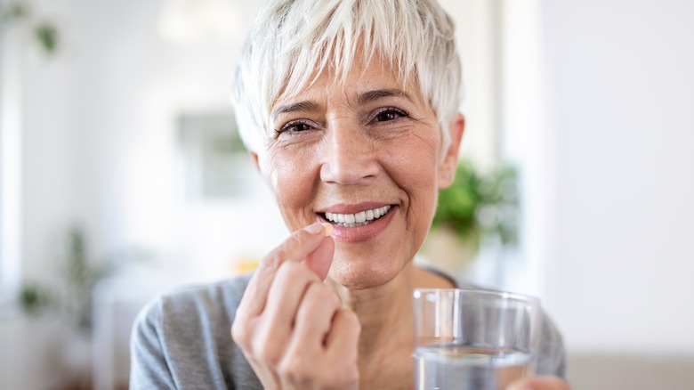 older woman taking a supplement