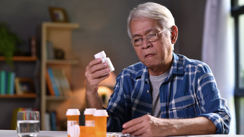 older man reading his medication labels