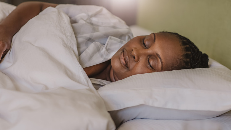 Woman sleeping in bed on her left side