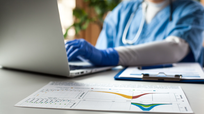 A medical provider looking over records on a computer