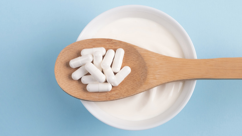 probiotic capsules on wooden spoon